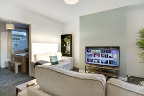 A modern living room with a sofa, a TV, and a small table. - Family two Bedroom Home Free Parking and Backyard (Crook)