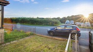 A residential area with a parked car, a fence, and a clear sky. - Family two Bedroom Home Free Parking and Backyard (Crook)
