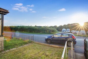 A residential area with a parked car, a fence, and a clear sky. - Family two Bedroom Home Free Parking and Backyard (Crook)