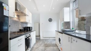 A modern kitchen with a built-in oven, microwave, and a coffee machine. - Classic 4 Bedroom Retreat Close to Infinity Bridge (Stockton-on-Tees)
