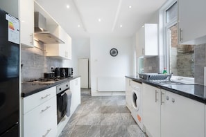 A modern kitchen with a built-in oven, microwave, and a coffee machine. - Classic 4 Bedroom Retreat Close to Infinity Bridge (Stockton-on-Tees)