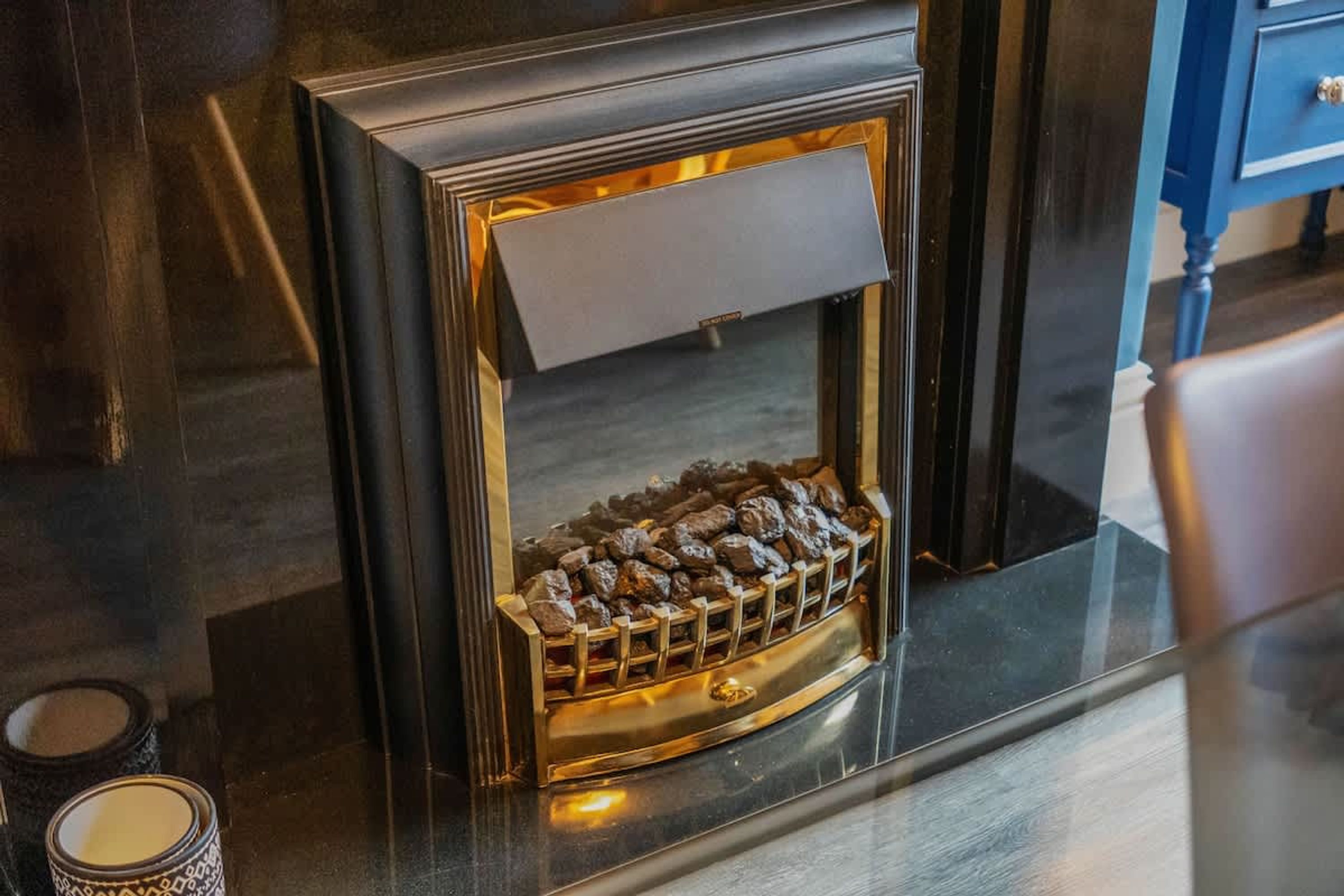 Ein Kamin mit einem Metallgitter und einem Holzrahmen.
