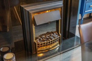 Una chimenea con rejilla metálica y marco de madera.