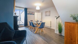 Ein stilvolles Loft-Zimmer mit Essbereich, großem Fenster und Blick ins Freie.