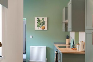 A kitchen with a radiator, cabinets, a countertop, and a wall-mounted plant. - 4BR in Hill Top House With Free Parking and Wifi (Durham)