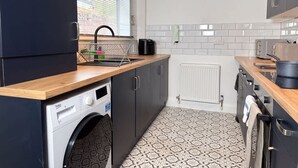 A compact kitchen with a washing machine, a sink, and a microwave. - Prime TS1 Location Walk to Shop Uni and Transport (Middlesbrough)