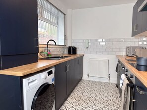 A compact kitchen with a washing machine, a sink, and a microwave. - Prime TS1 Location Walk to Shop Uni and Transport (Middlesbrough)