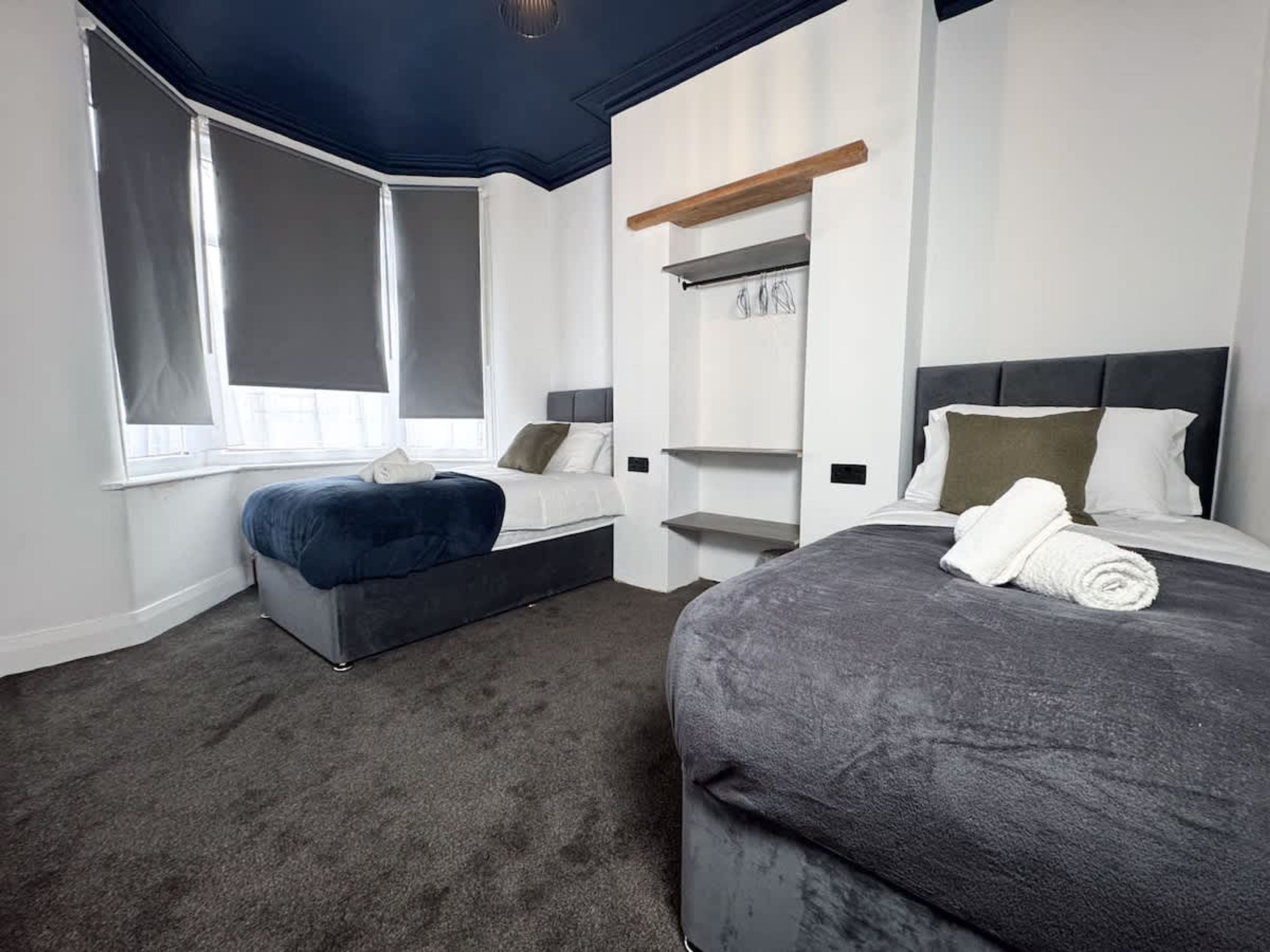 Ein Hotelzimmer mit einem Bett, einer Sitzecke, einem Fenster und integrierten Regalen.