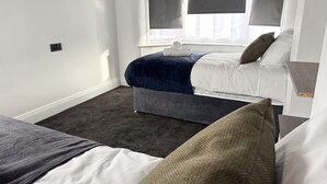 A bedroom with a bed, a bench, and a window with blinds. - Prime TS1 Location Walk to Shop Uni and Transport (Middlesbrough)