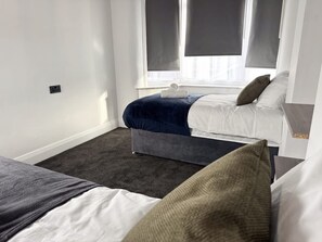 A bedroom with a bed, a bench, and a window with blinds. - Prime TS1 Location Walk to Shop Uni and Transport (Middlesbrough)