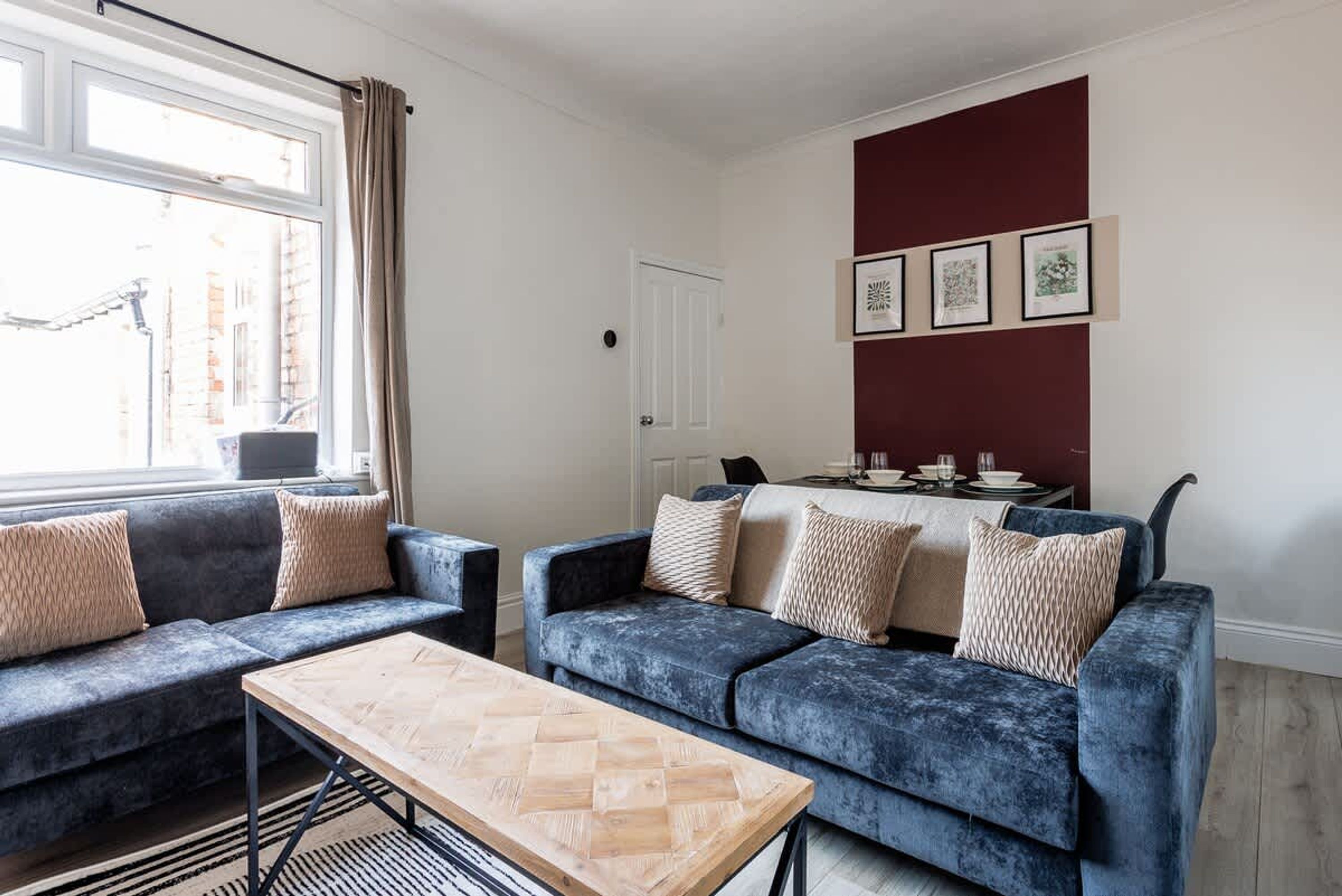 A modern living room with two sofas, a coffee table, and a dining area with a table set for four.