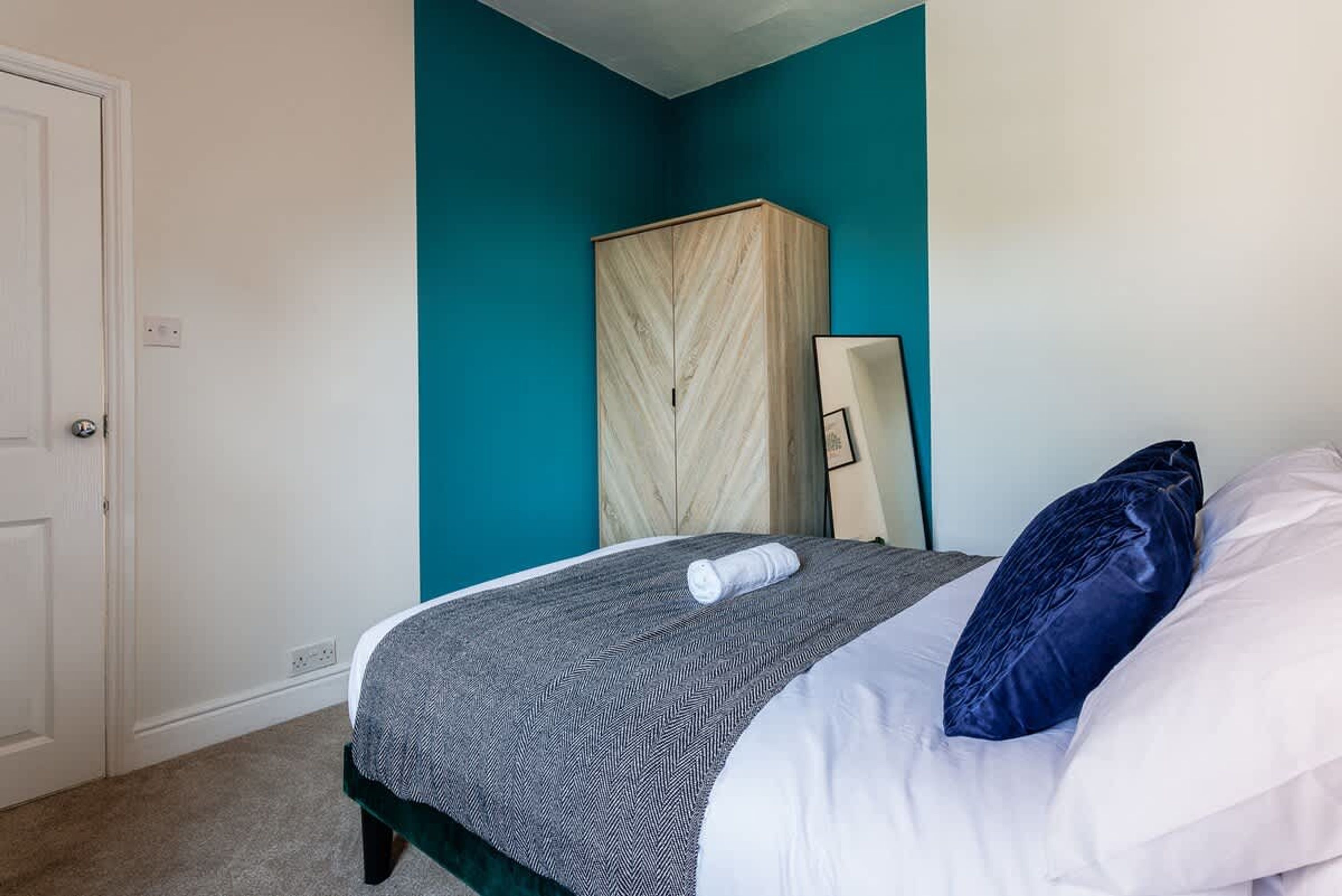 Une chambre à coucher avec un lit, une armoire et un miroir.