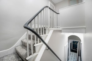 Eine Treppe mit weißen Geländern und einer Teppichstufe.