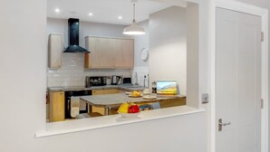 Een compacte keuken met een ingebouwde magnetron, broodrooster en waterkoker.