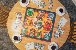 A board game with a map layout, surrounded by cups of coffee on a round table. - Spacious 1 Bedroom in Hartlepool With Wifi (Hartlepool)