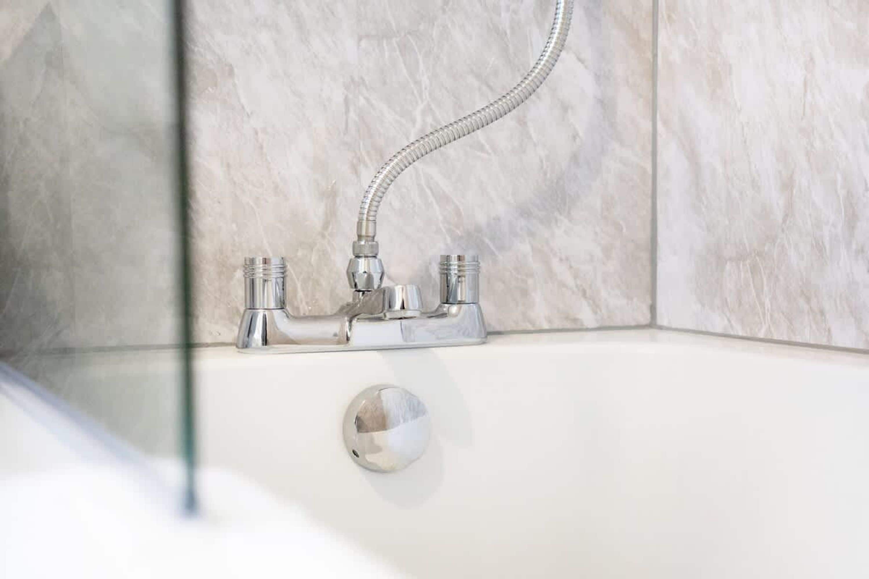 A bathroom with a shower, a bathtub, and a glass-enclosed shower area.