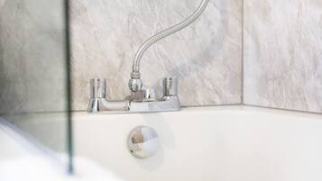 A bathroom with a shower, a bathtub, and a glass-enclosed shower area.