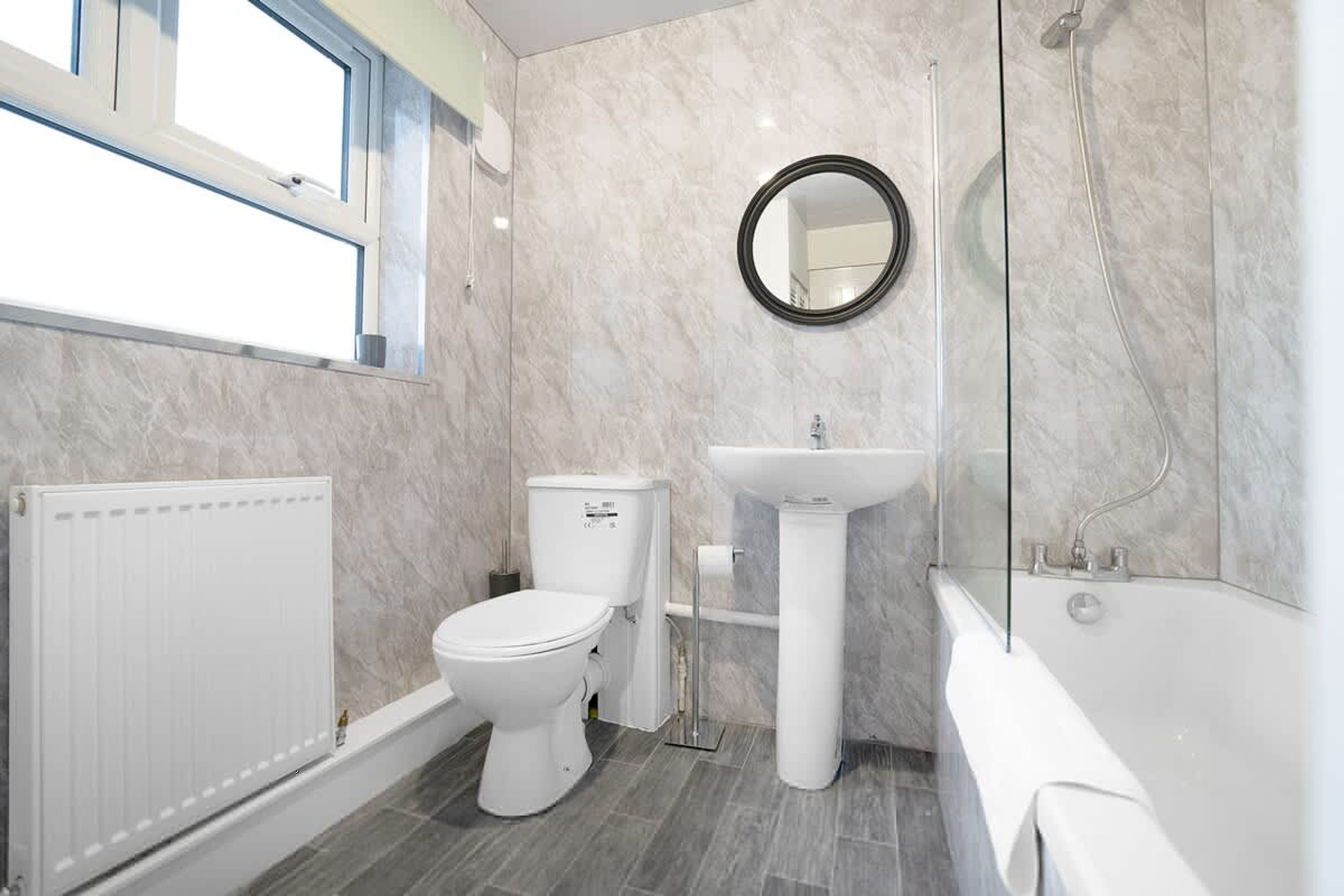 Un baño moderno con inodoro, lavamanos y ducha.