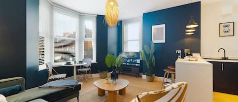 Un salon moderne avec un canapé, des fauteuils, une table basse et un téléviseur.