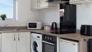 Eine moderne Küche mit Mikrowelle, Wasserkocher und Geschirrspüler.