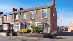 A two-story residential building with a brick facade, multiple windows, and a small garden area in front. - Spacious Retreat at Durham Road (Spennymoor)