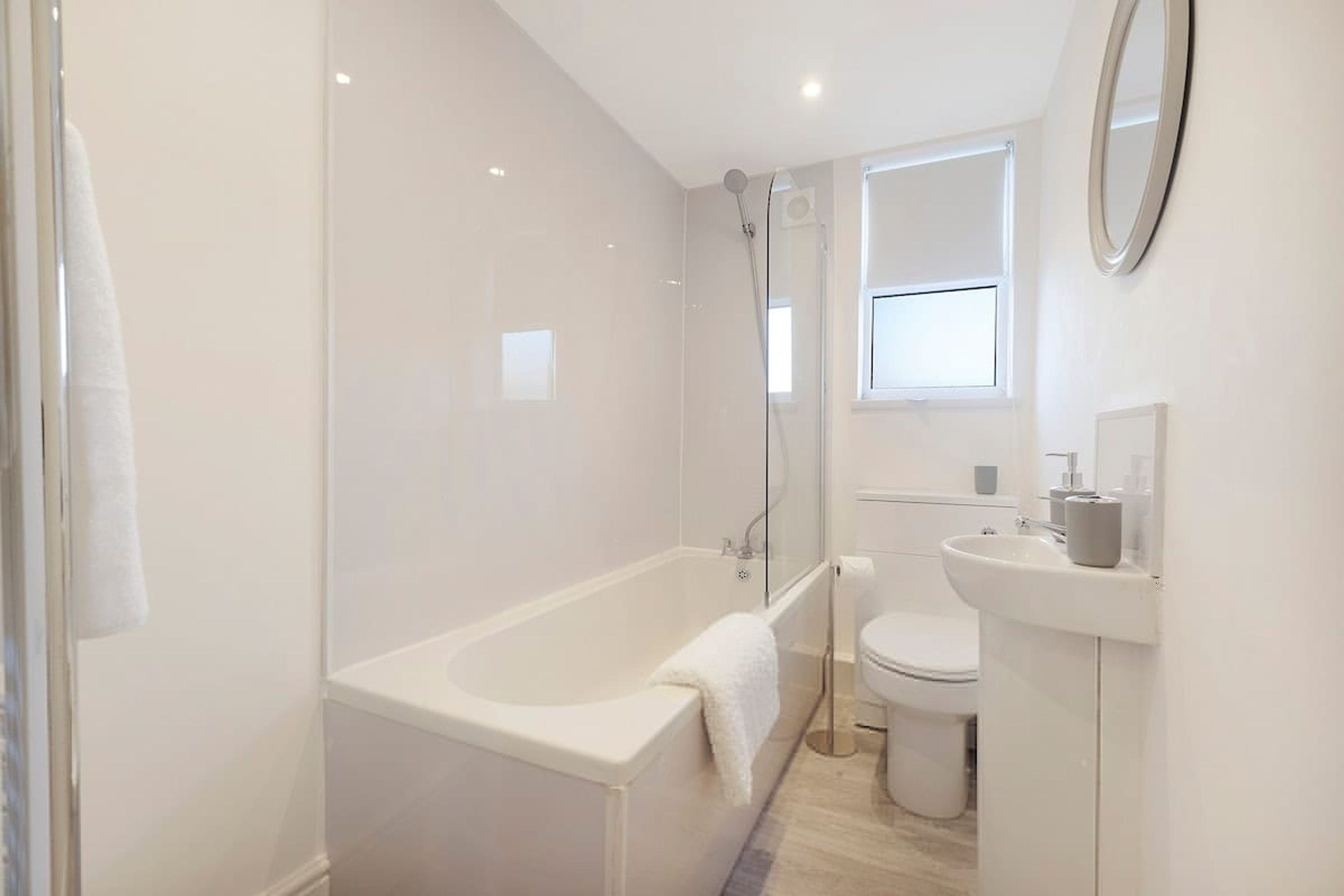 A modern bathroom with a bathtub, toilet, and sink.