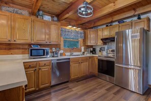 A kitchen with wooden cabinets, stainless steel appliances, and a wooden ceiling. - Bears on Beach Front * 3 beds * 2 bath * sleeps 9 (Sevierville)