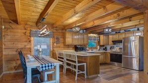 Ein Holzblockhaus-Interieur mit Essbereich, Küche und einem Schild an der Wand.