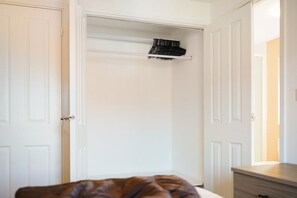 A bedroom with a bed, a dresser, and a closet with a hanging rack. - 3 Bedroom With Parking Close to Town Centre (Redcar)