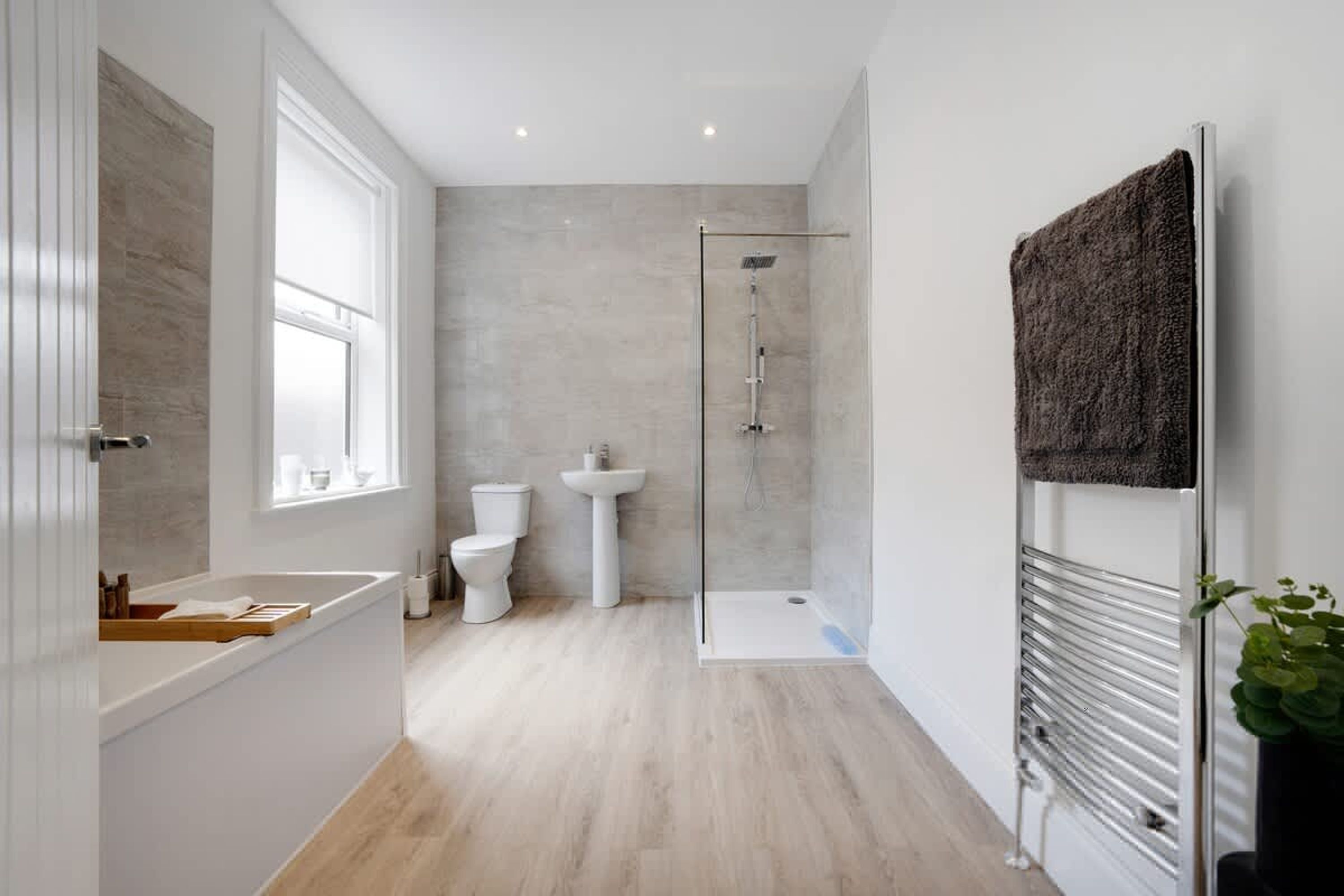 A modern bathroom with a bathtub, toilet, and shower.