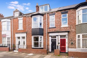 A row of terraced houses with distinct architectural features, including bay windows and a variety of door styles. - 4BR South Shields Stay Sleeps 8 by Stay With Us (South Shields)