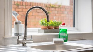 A kitchen sink with a faucet, a dish soap bottle, a sponge, and a dish rack. - 4BR South Shields Stay Sleeps 8 by Stay With Us (South Shields)