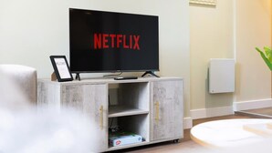 A modern living room with a flat-screen TV on a wooden cabinet, a framed welcome sign, and a small plant. - Stylish 1-bed Stay in the Heart of Barnard Castle (Barnard Castle)
