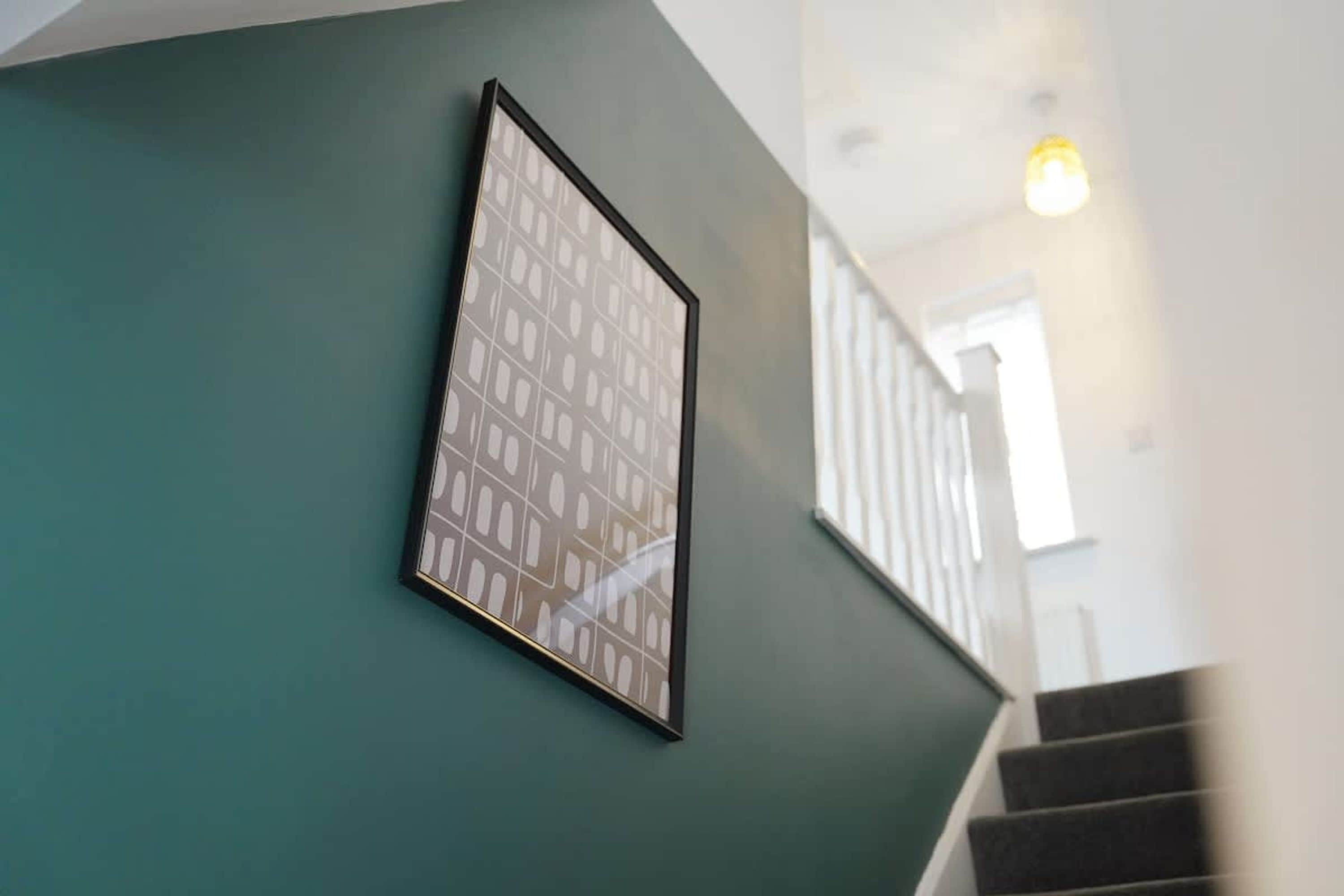 A staircase with a handrail and a wall-mounted picture frame.