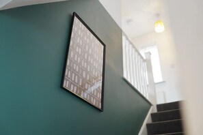 Uma escada com corrimão e um quadro fixado na parede.