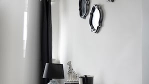 Una stanza minimalista con una scrivania, una lampada, una scultura decorativa e specchi a parete.