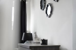 A minimalist room with a desk, a lamp, a decorative sculpture, and wall-mounted mirrors. - Family Coastal Three Bedroom House Parking and Wifi (Saltburn-by-the-Sea)