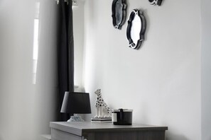 A minimalist room with a desk, a lamp, a decorative sculpture, and wall-mounted mirrors. - Family Coastal Three Bedroom House Parking and Wifi (Saltburn-by-the-Sea)