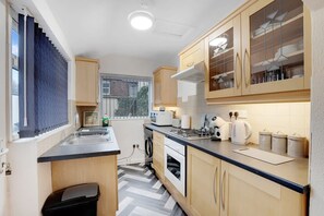 A compact kitchen with a built-in oven, a microwave, and a gas stove. - 2BR in Dundee Free Wifi and Indoor Fireplace (Darlington)
