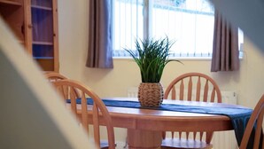 A dining table with a woven plant pot, surrounded by wooden chairs. - 2BR in Dundee Free Wifi and Indoor Fireplace (Darlington)