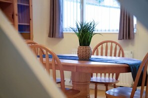 A dining table with a woven plant pot, surrounded by wooden chairs. - 2BR in Dundee Free Wifi and Indoor Fireplace (Darlington)