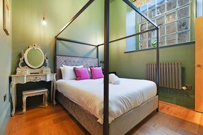 A four-poster bed with a headboard, a bedside table with a mirror, and a radiator. - Central 2 Bed Near Barnard Castle Bowes Museum (Barnard Castle)