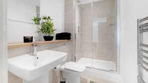 Ein modernes Badezimmer mit Waschbecken, Toilette und Duschkabine.