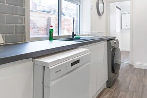 Una cocina con lavavajillas, ventana y vistas al exterior.