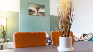 A dining area with a table, chairs, and a vase with dried plants. - Spacious Five Bedroom Family Home Group Stay Wifi (Sunderland)