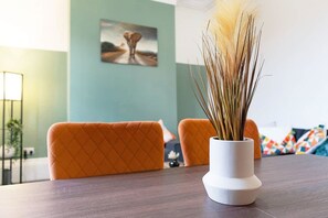 A dining area with a table, chairs, and a vase with dried plants. - Spacious Five Bedroom Family Home Group Stay Wifi (Sunderland)