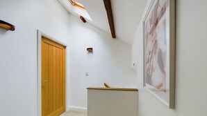 Ein Flur mit einer Holztür, einem weißen Heizkörper und einem gerahmten Bild an der Wand.