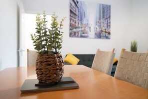 A dining table with a woven plant pot on a coaster, surrounded by chairs. - Stylish Home Near Darlington Town Centre (Darlington)