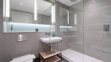 Une salle de bain moderne équipée de toilettes, d’un lavabo et d’une douche.