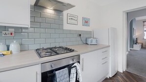 Eine moderne Küche mit Gaskochfeld, Toaster und Kühlschrank.